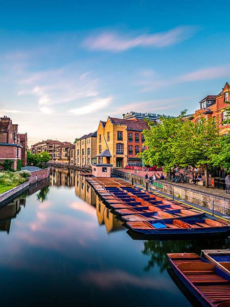 A row of punts on a Cambridge city canal at sunset. England.