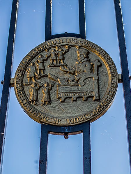 Uppingham School coat of arm on barred fence, in Uppingham, Rutland, England.