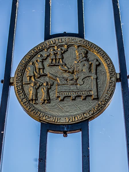 Uppingham School coat of arm on barred fence, in Uppingham, Rutland, England.