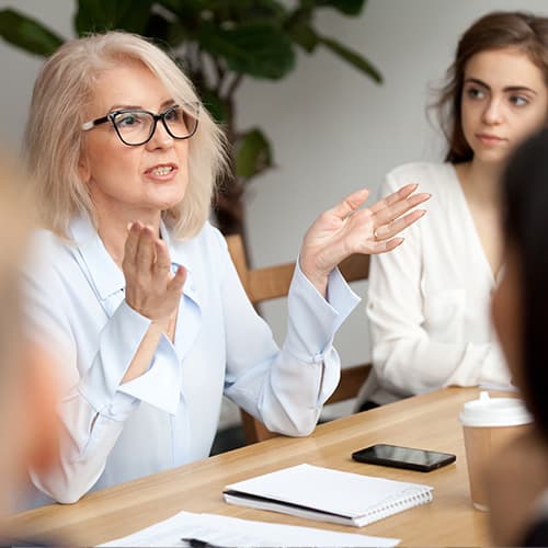 Mature lady leading the conversation in a meeting.