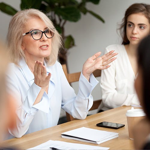 Mature lady leading the conversation in a meeting.